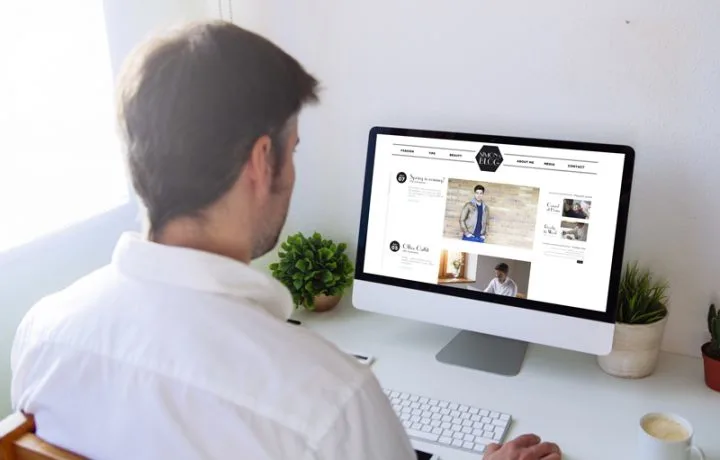 A man types at a desktop computer.