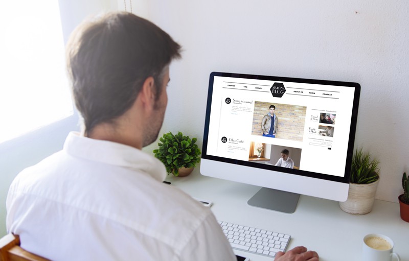 A man blogging on a desktop computer.