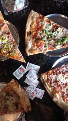 Several slices of pizza on metal plates.