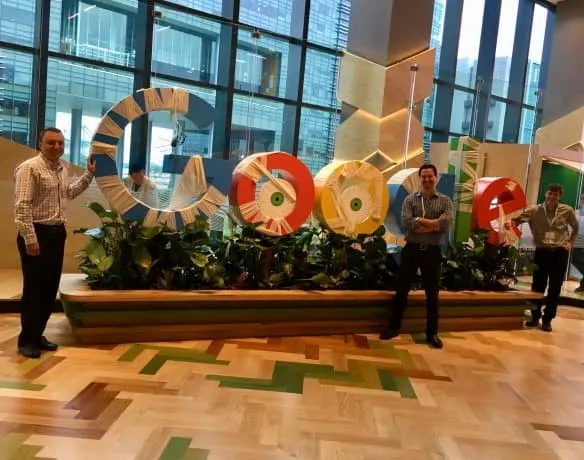 Brad Hagman (left), Eric Hochberger (center) and Steve Marsi (right) by a Halloween-decorated Google sign at Google's Singapore offices.