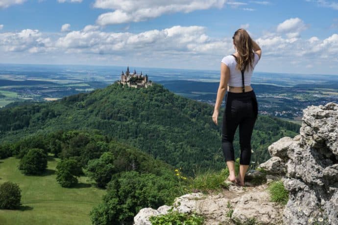 Kristin Addis looks out over a mountain range from a rocky outcrop.