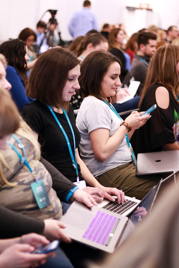 MVCoin attendees taking notes on phones and laptop computers.