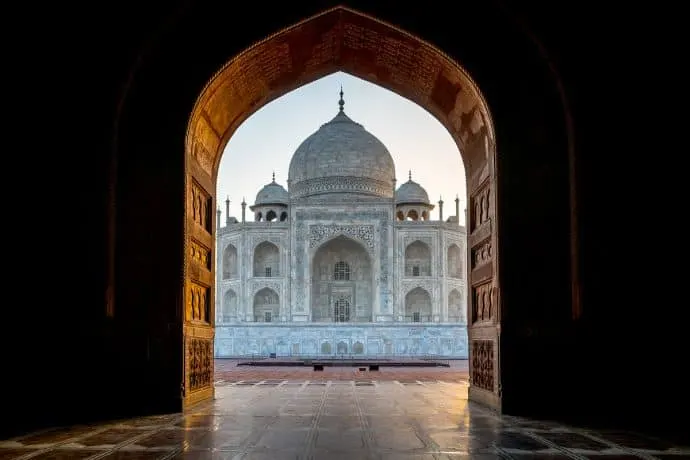 The Taj Mahal seen through an archway entrance.