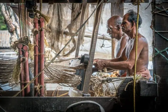 Men at work in India processing coir (used to make doormats and rope),