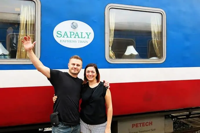 Andrzej Ejmont of Wanderlust Storytellers stands in front of a Sapaly Express Train.