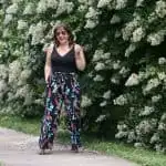 Alison Gary from Wardrobe Oxygen standing in front of flowery bushes