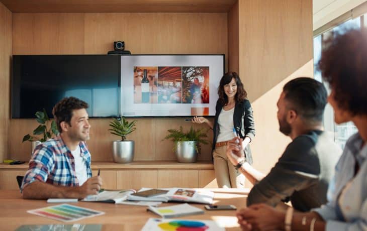 A group of people gathered in a meeting room, conversing.