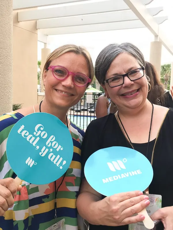 Haven attendees holding Mediavine-branded hand fans reading "Go for teal, y'all!".