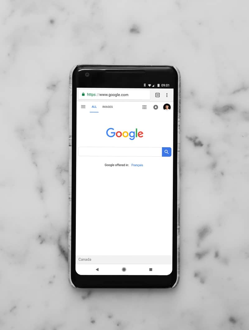 A mobile phone opened to the Google search bar home page.