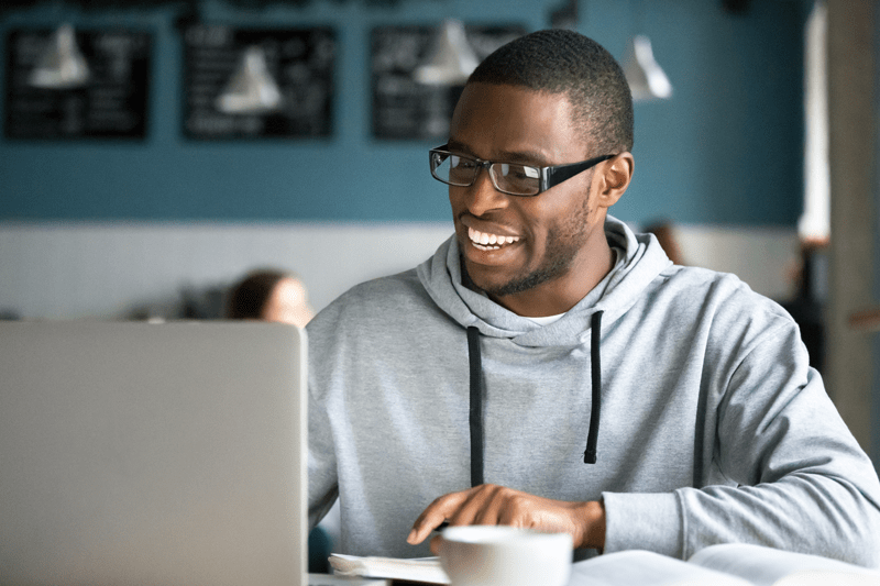 A man uses a laptop computer in a cafe.