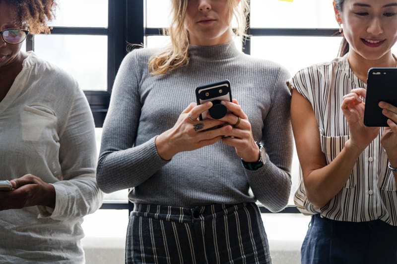 Three women using mobile phones.