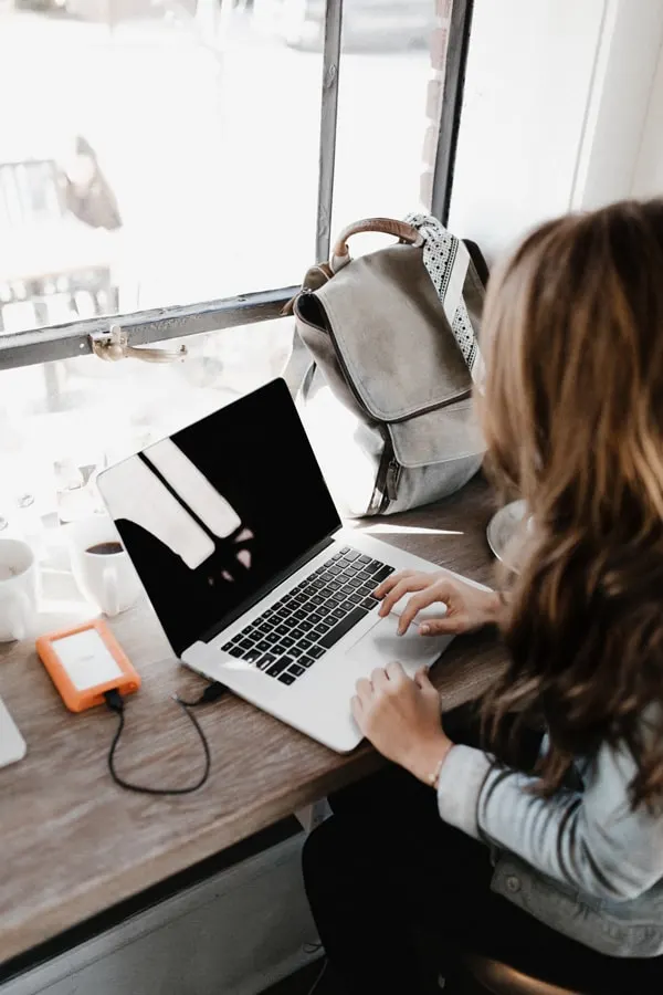 A woman typing on a laptop computer.