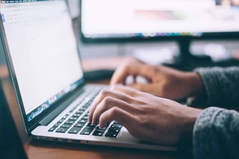 person's hands using a laptop computer