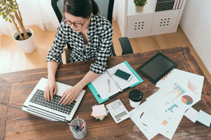 Blogger getting ready for q1 with a computer and printouts of analytics