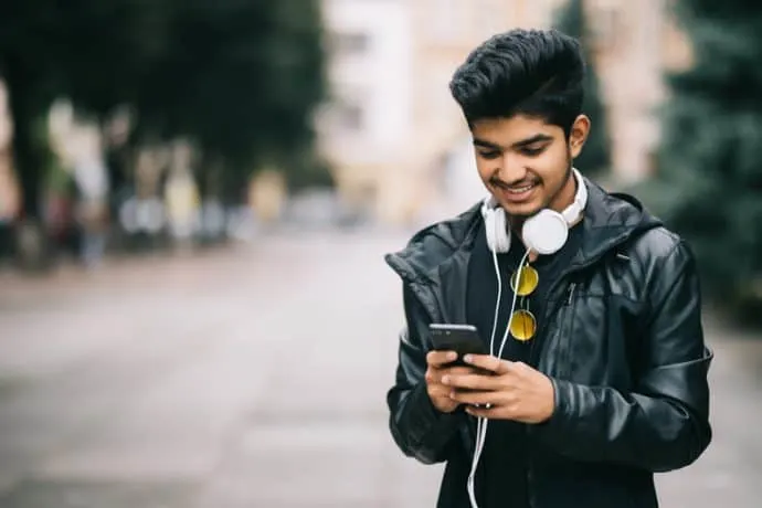 man using phone walking on street