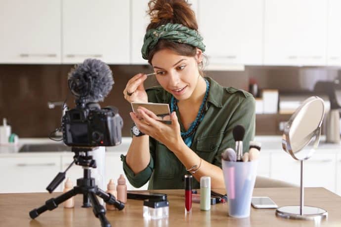 woman doing make-up in front of a camera
