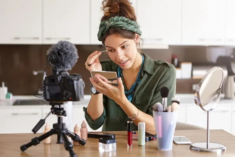 A beauty vlogger filming with makeup.