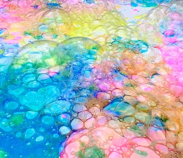A photograph of colored bubbles on a flat surface.