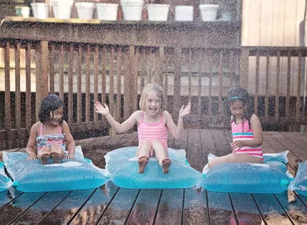 Children sitting on colored water blobs.