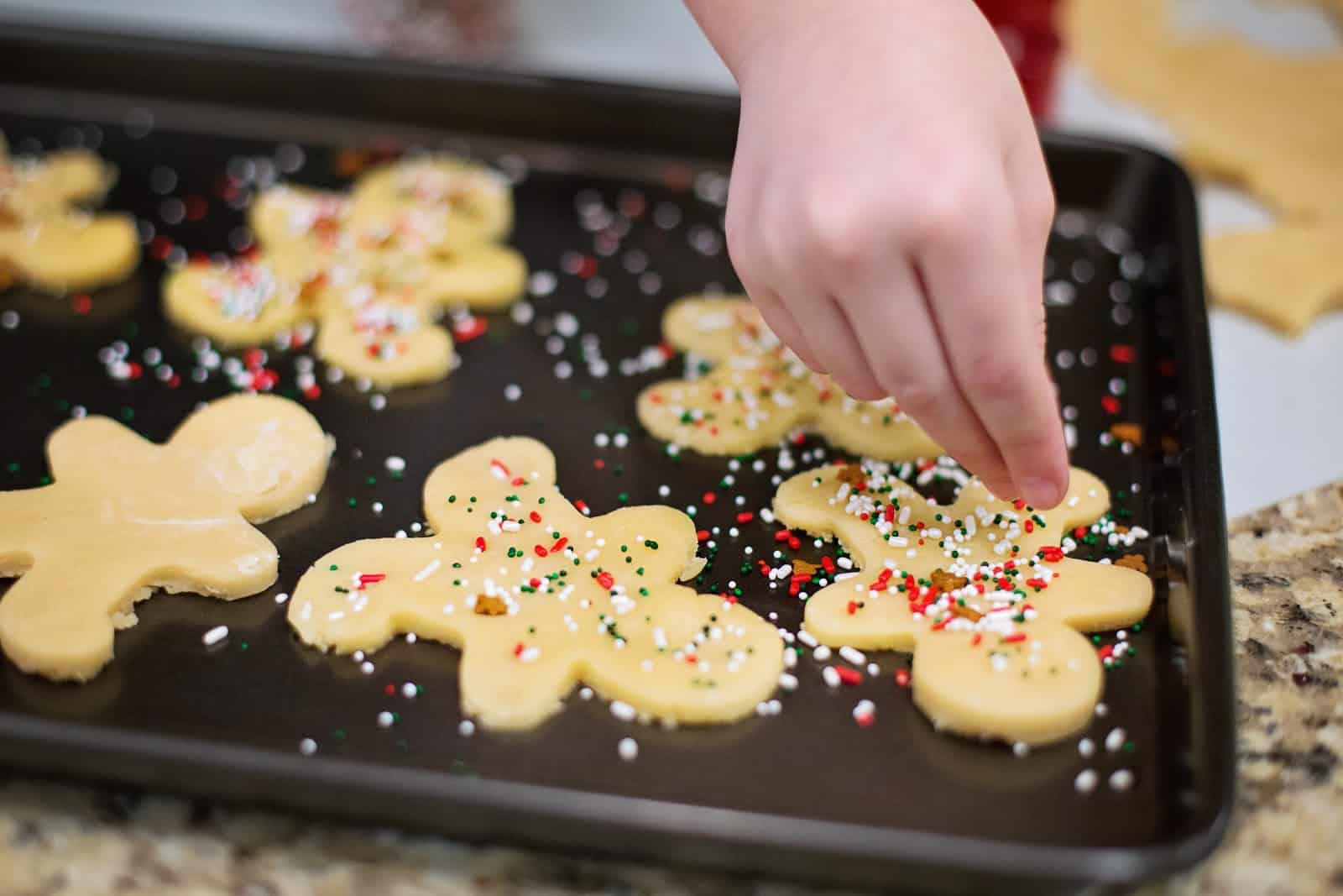 Adding sprinkles to sugar cookies.