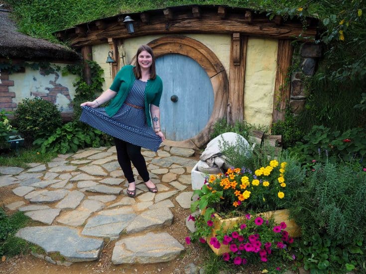 Amanda Williams of A Dangerous Business embracing her inner Hobbit in front of a set of the Hobbit Hole.