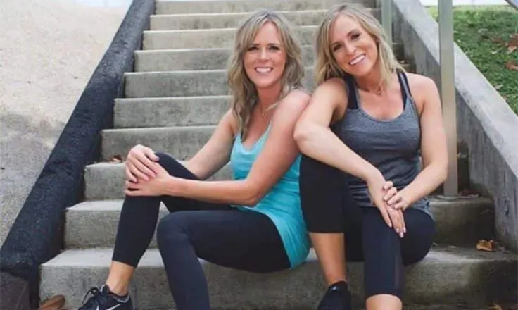 sorey and kalee posing on stairs in fitness attire