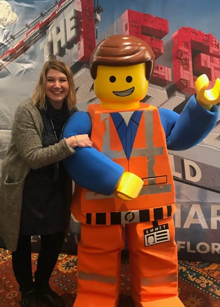 Jenny standing beside a life-size replica of Emmet, the main character of The Lego Movie.