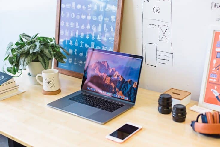 Desk top with computer, smart phone, coffee and office supplies.