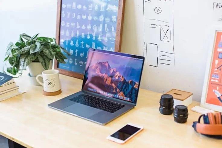 Desk with coffee, computer, smart phone and office supply organizer on top.