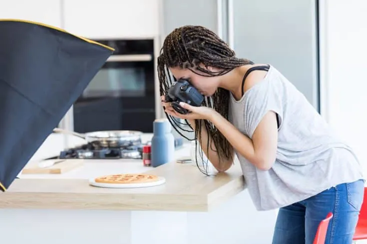 woman taking a picture of a waffle on a plate