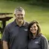 jim and mary standing together in front of a fence