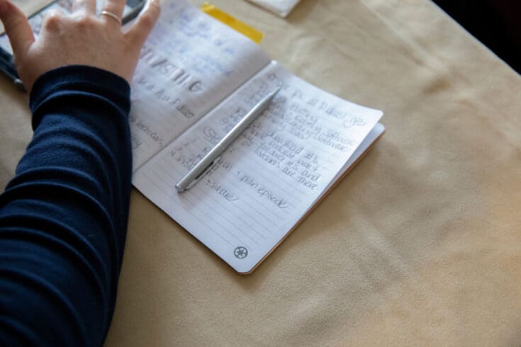 A woman writing notes in a notebook.