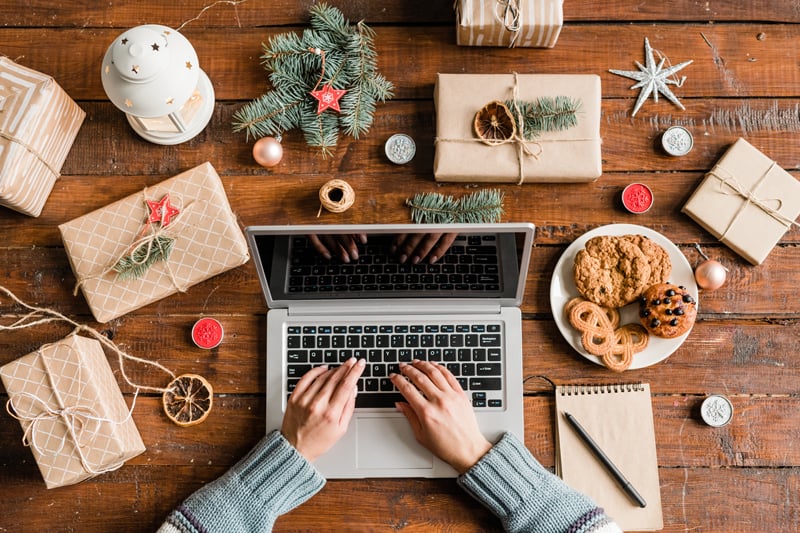 laptop on table with holiday decorations