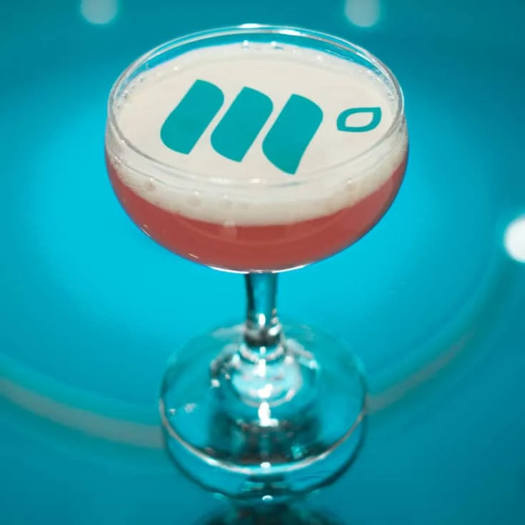 A cocktail with the Mediavine logo on top of the fizz in edible paper.