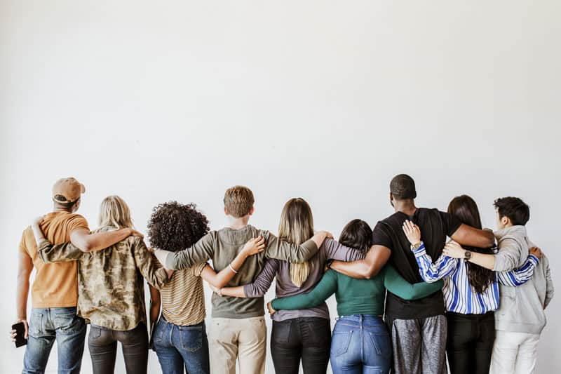 photo of people of multiple races with their arms around each other