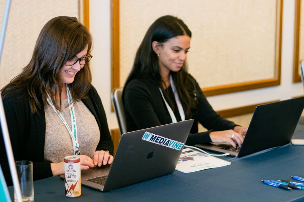 two mediavine team members typing on their laptops