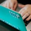 woman's hands typing on a teal computer covered in Mediavine stickers