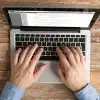 above view of person's hands typing on a laptop