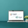Create and Grow logos shown on a laptop on a teal wall and desk
