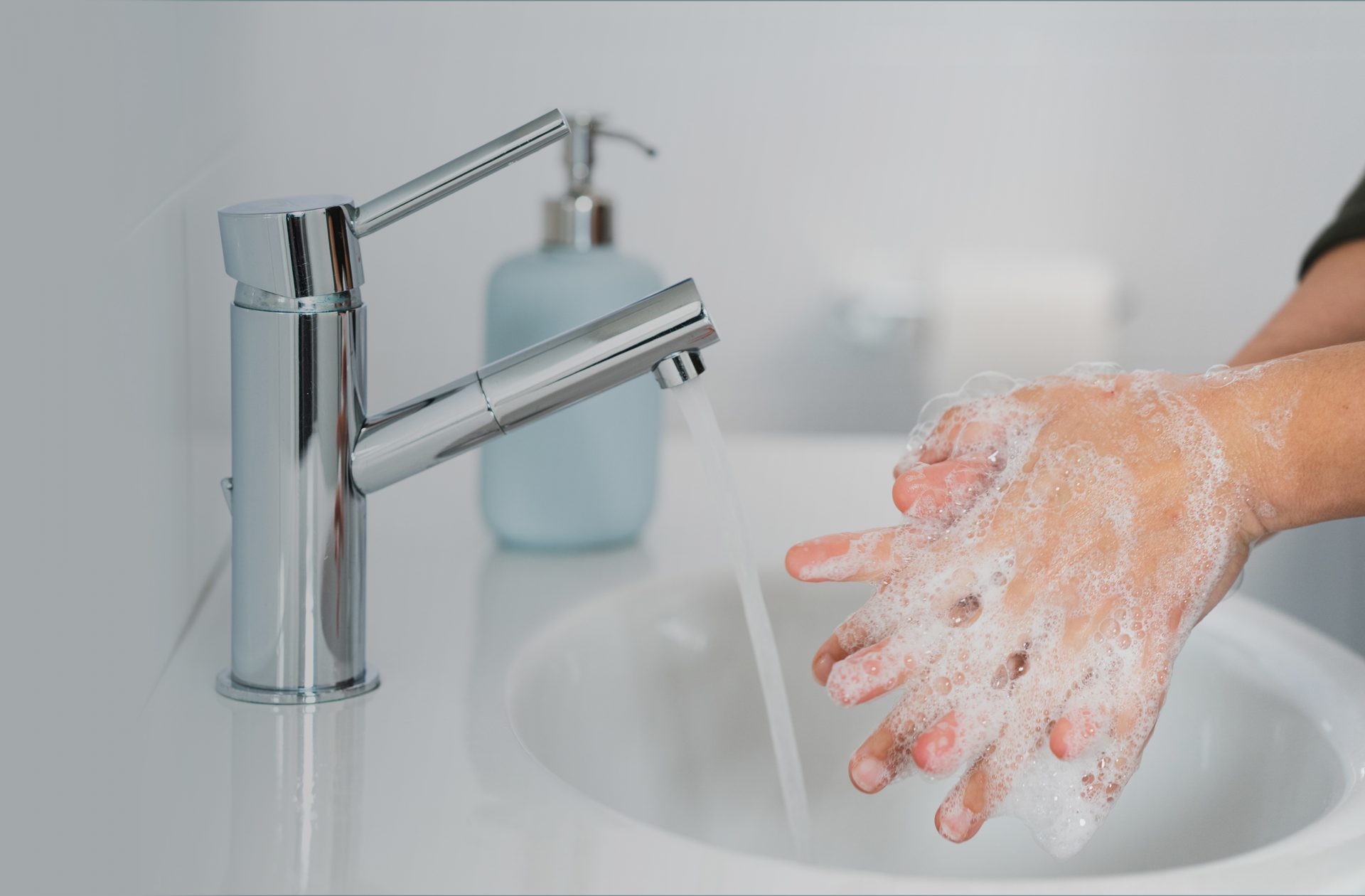 person washing their hands in a gray bathroom