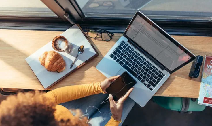 above view of woman on phone and laptop