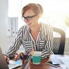 woman sitting at desk smiling at laptop