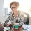 woman sitting at desk smiling at laptop