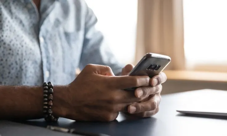 close up of mans hands holding phone