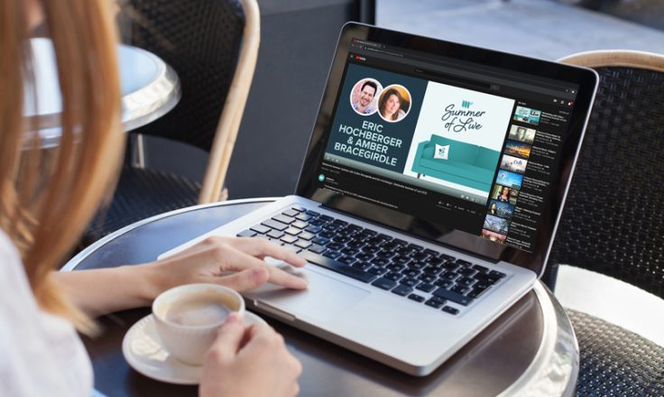 woman watching summer of live on laptop in a cafe