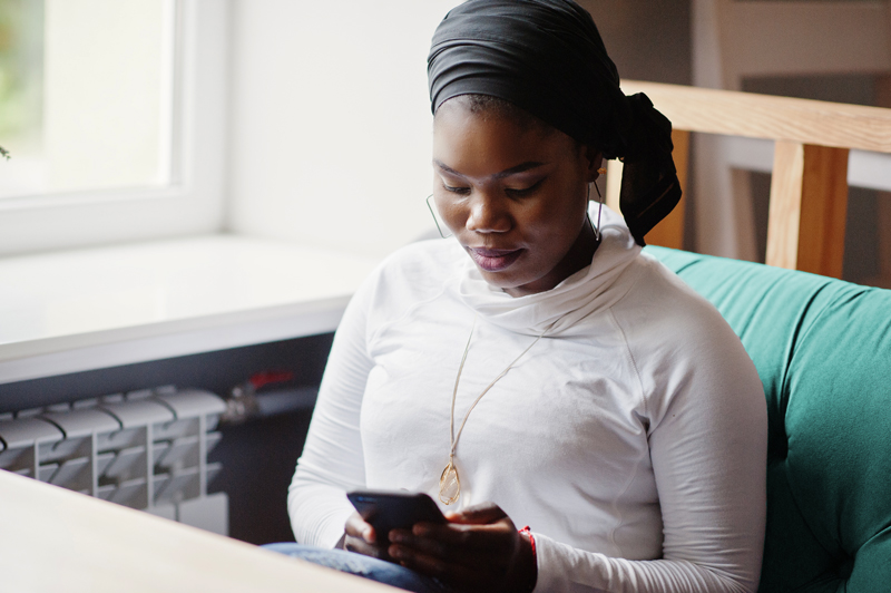 woman sitting on phone in lounge area