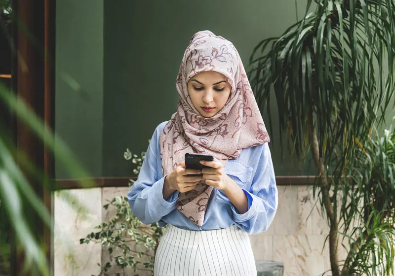 woman on phone surrounded by plants