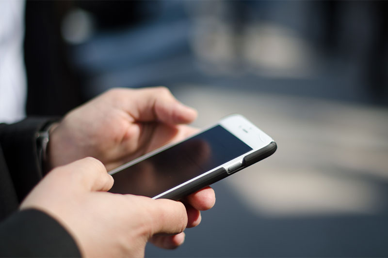 hands holding phone touching screen