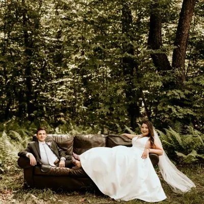 ruthie stewart and husband sitting on a couch in nature on their wedding day