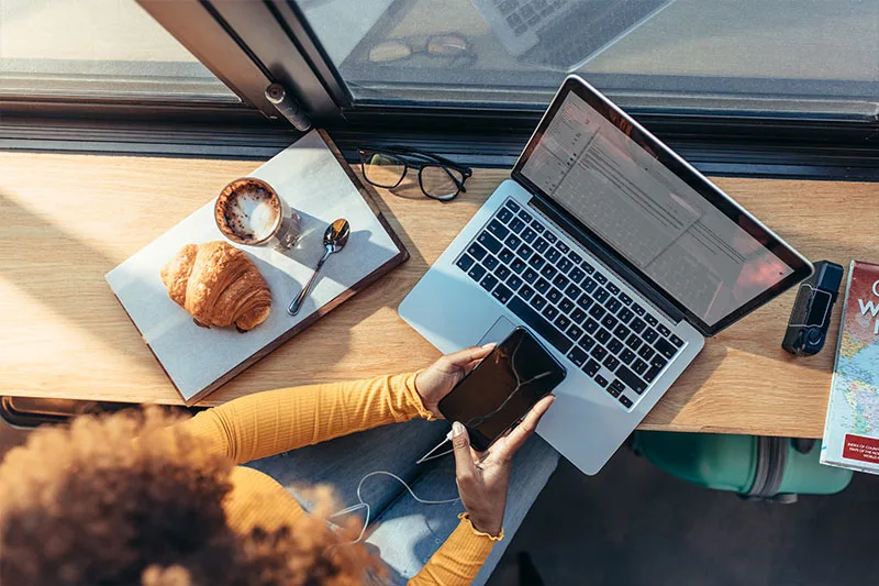 woman in cafe on laptop and phone